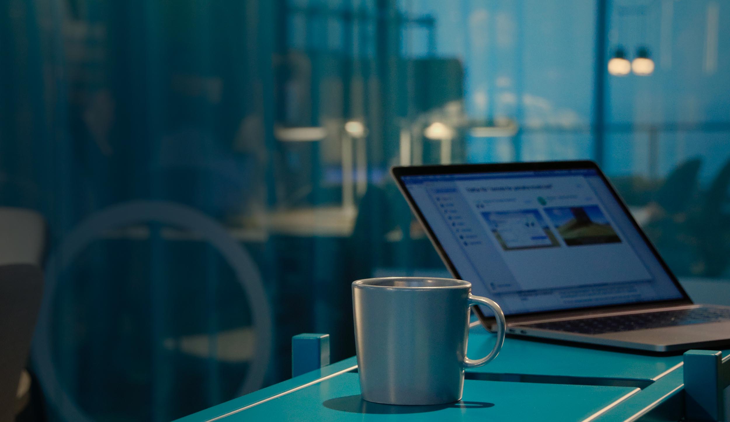 A cup of coffee beside a computer displaying NXT